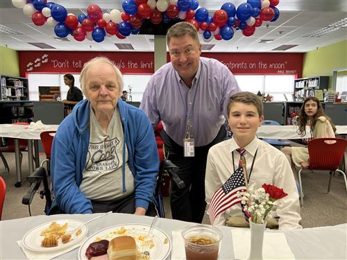 Veteran greeted by Principal Shannon Brown and student at Liberty Middle